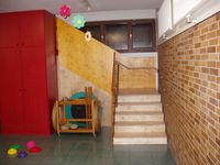 Treppe-im-Kindergarten-mit-intergiertem-Einbaumoebel-aus-rotem-MDF
